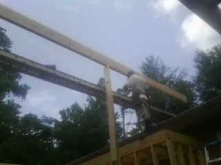 Carpenter setting a ridge beam over a new addition frame — Ice Dam Removal by Roofing Brothers in Picabo