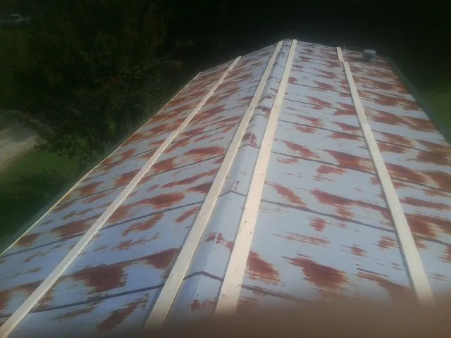 Rusted metal roof panels with new wood purlins before replacement — Storm Damage Roof Repair in Picabo by Roofing Brothers