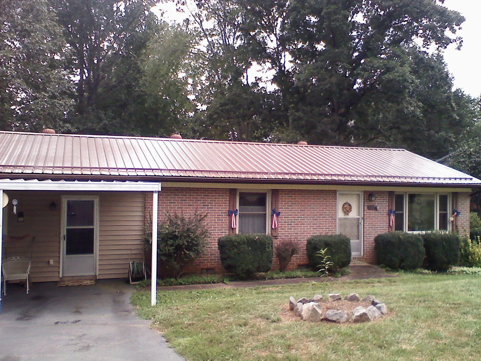 Bronze metal roof and carport on a brick ranch home — Roof Repair work by our crew in Picabo